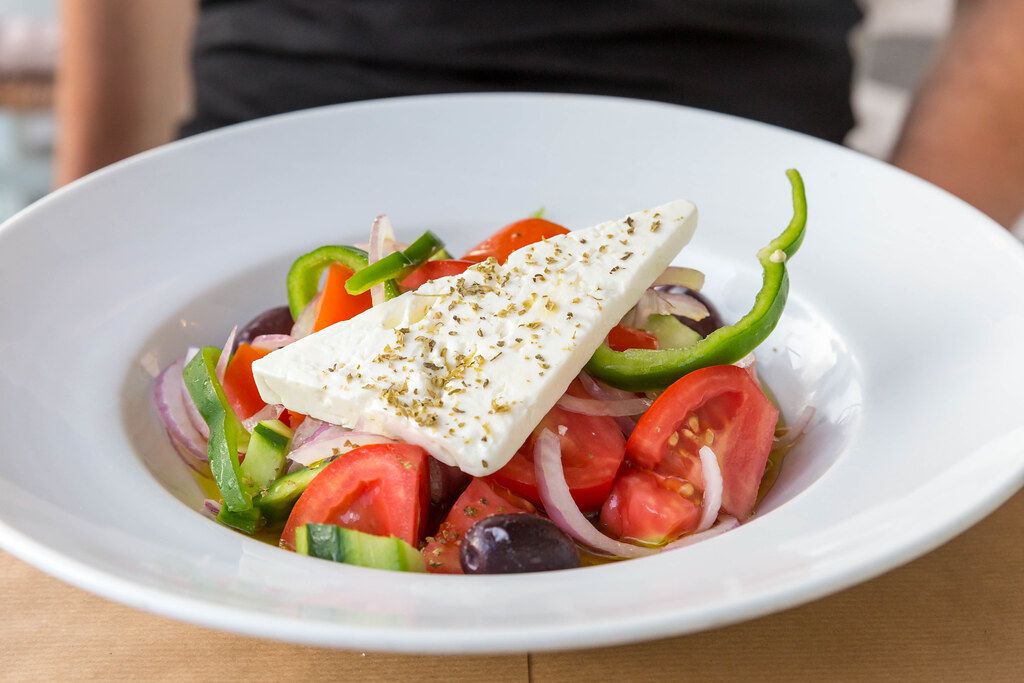 Bunter, griechischer Salat, mit Fetakäse und frischem Gemüse, auf einem ...