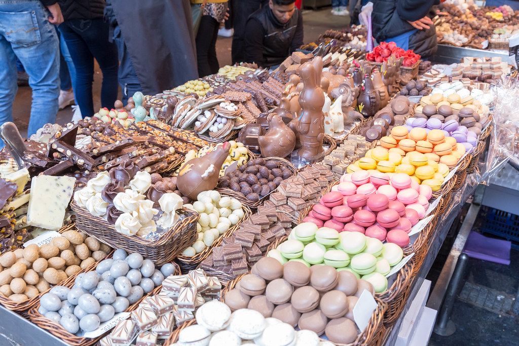 Buntes Sortiment mit Gebäck und Schokolade am Süßigkeitenstand in der größten Markthalle Barcelonas (Spanien) 