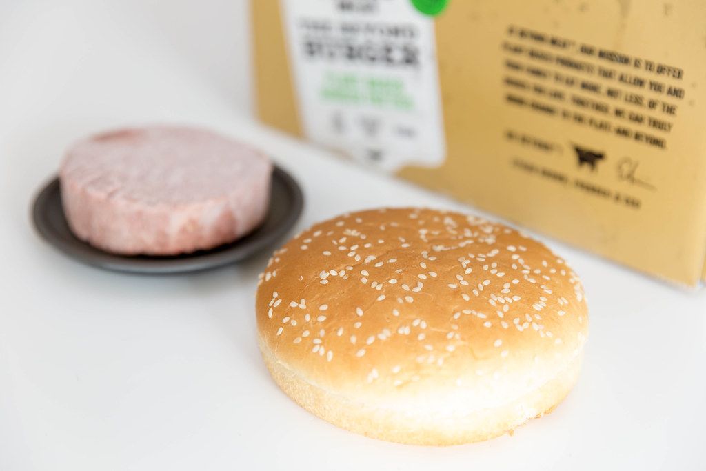Burger bun in close-up with Beyond Meat plant-based, soy free and gluten free burger patty on black plate