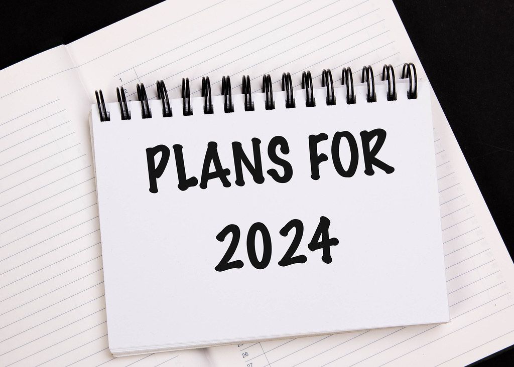 Man writing 2024 plans in notebook Creative Commons Bilder