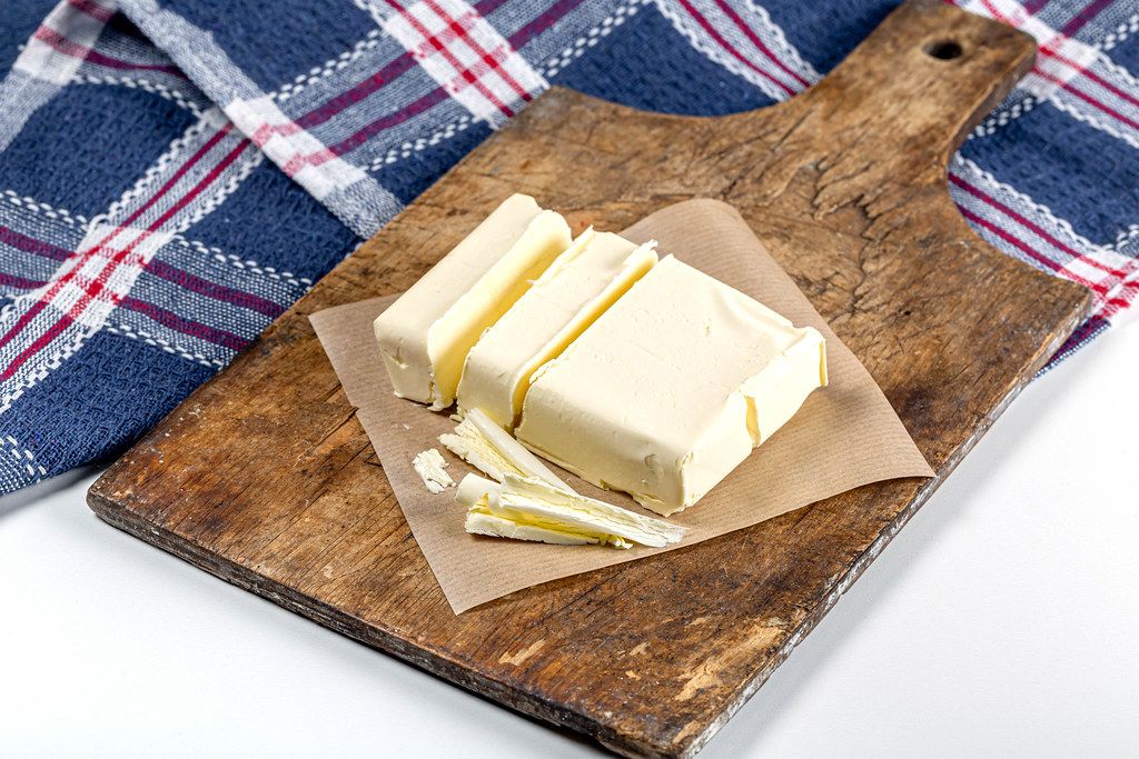 Butter slices on an old kitchen Board with a blue kitchen towel