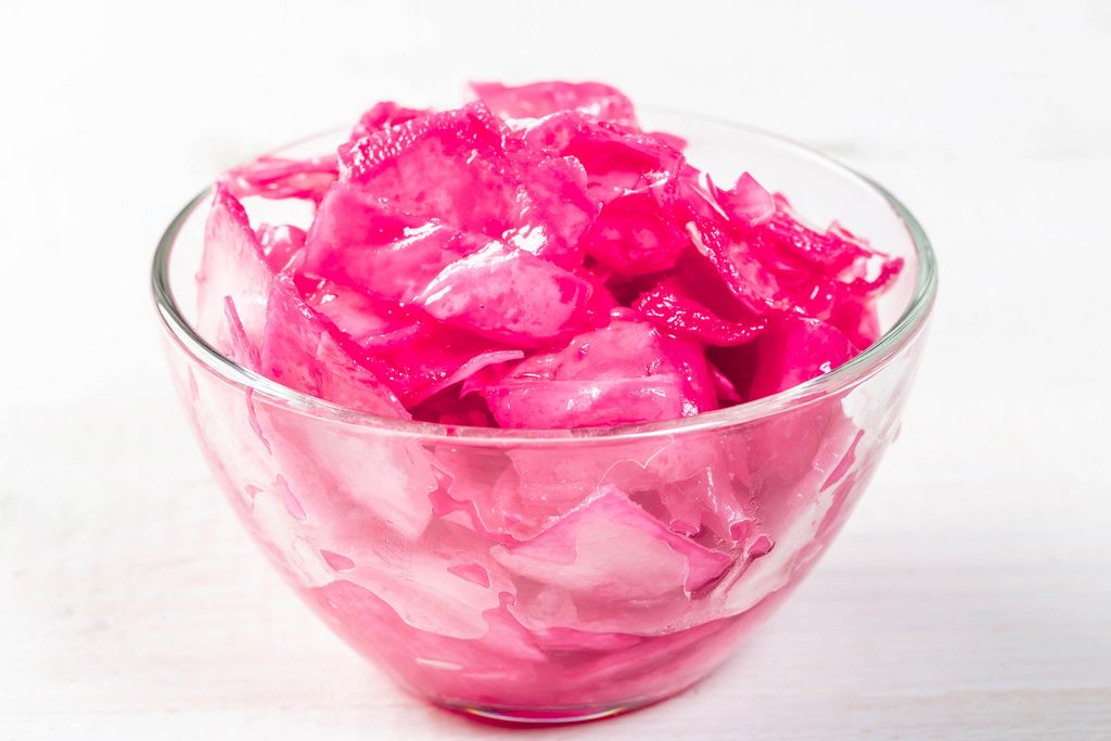 Cabbage pickled in a glass bowl on a white background