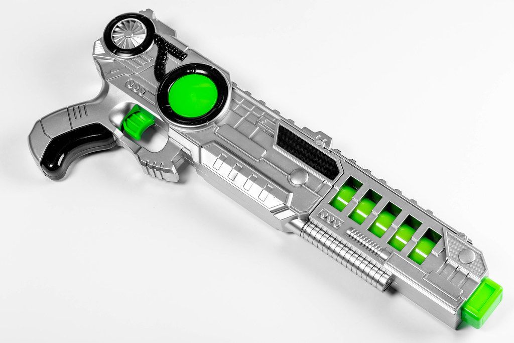 Children's plastic toy gun on white background (Flip 2019)