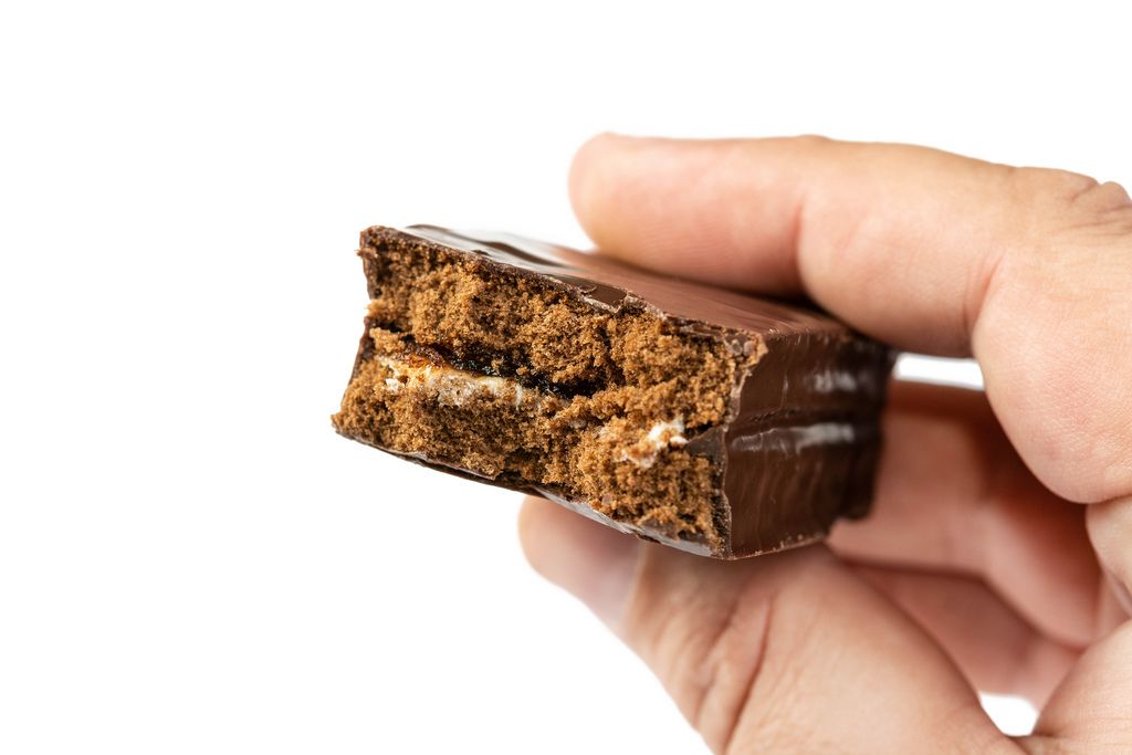 Chocolate Bar with Caramel in the hand above white background (Flip 2019)