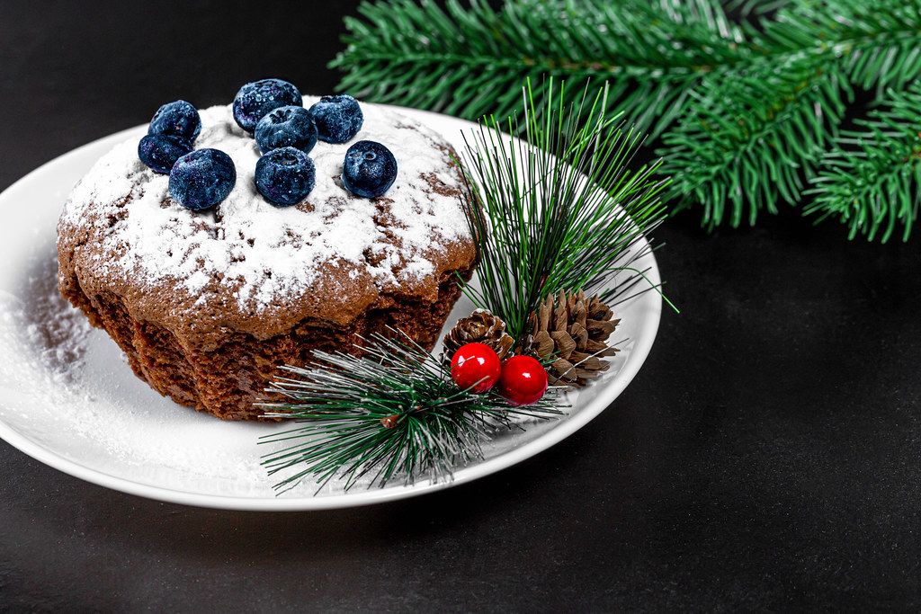 Chocolate cupcake with blueberries on a black background. Christmas dessert (Flip 2019)