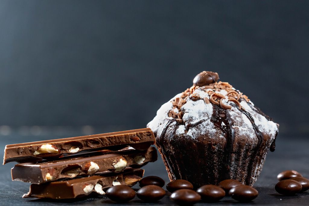 Chocolate muffin with chocolate pieces on dark background
