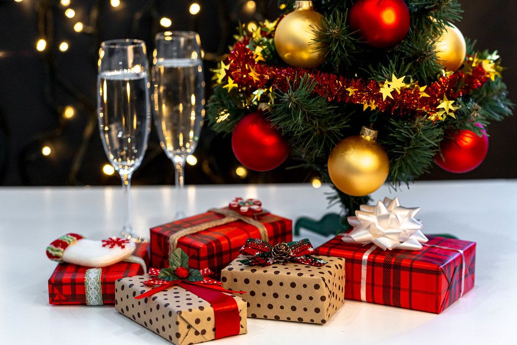 Christmas background with Christmas tree, gifts and glasses of champagne