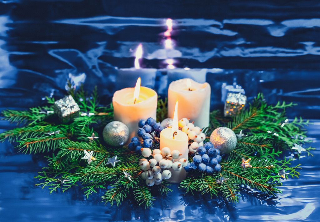 Christmas burning candles and Christmas tree branches on blue  background