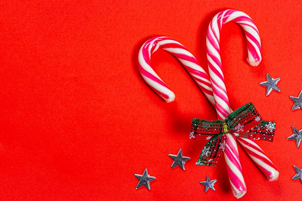 Christmas candy canes on a red background with stars