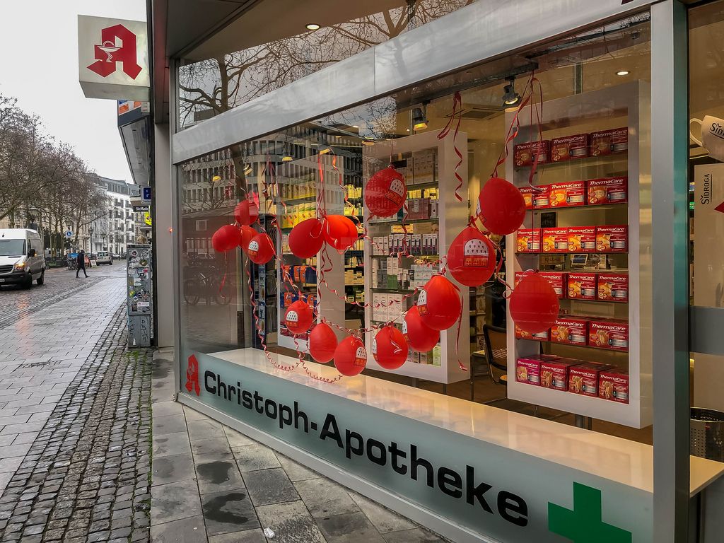 Christoph-Apotheke am Kaiser-Wilhelm-Ring zeigt kleines Kölner Stadtwappen auf Luftballons im Schaufenster