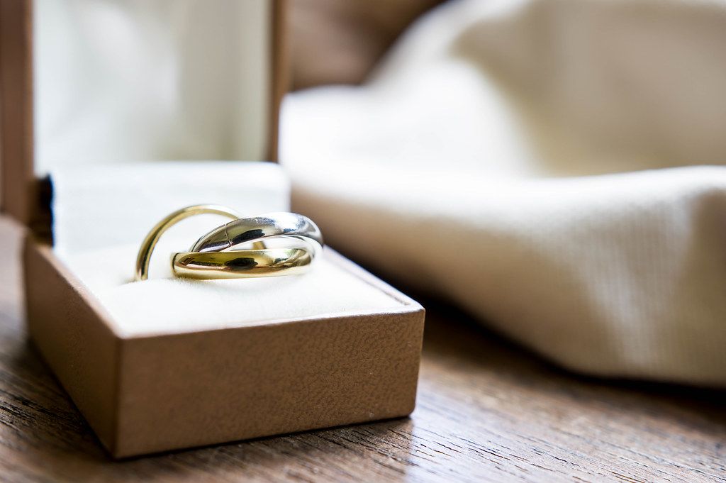 Close Up Bokeh Photo of Wedding Rings in a Ring Box on Wooden Table