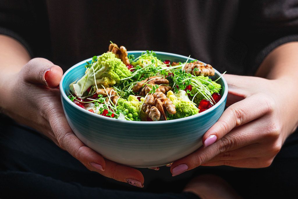 Close-up of a bowl of salad in a woman's hands