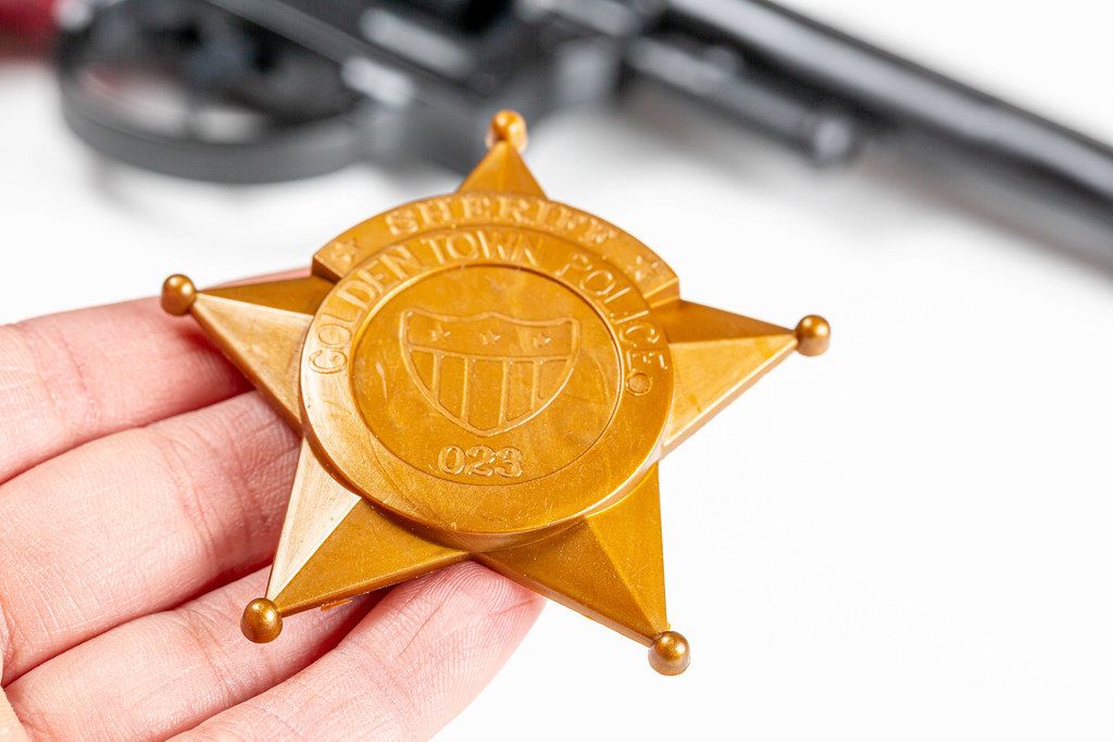 Close-up of a plastic toy police badge in hand