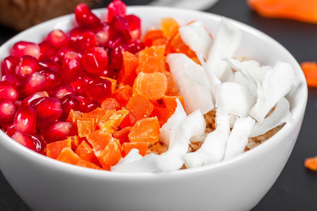 Close- up of oatmeal with coconut, dried apricots and pomegranate