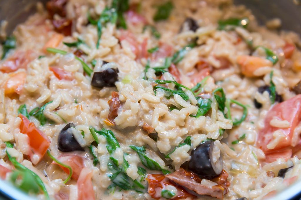 Close-up of Risotto with dried tomatoes, olives, walnuts and Italian hard cheese