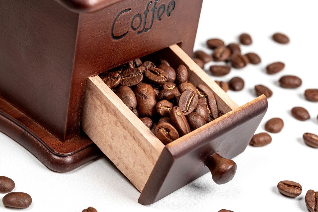 Close-up of roasted coffee beans in coffee grinder box