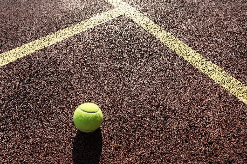 Close Up of Tennis Ball on Tennis Hard Court at Sunny Weather