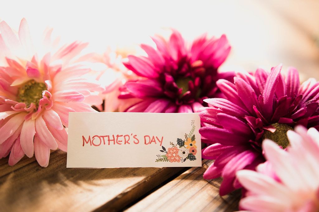 Close Up Photo of a Table Name Card with Text Mother's Day with beautiful flowers around it