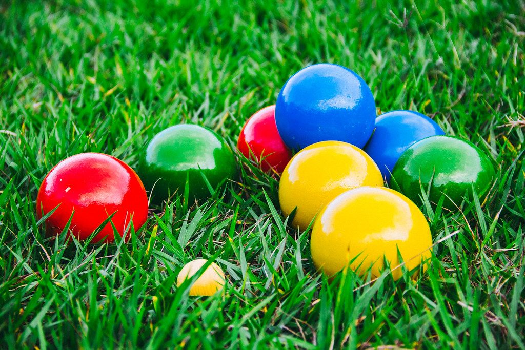 Close Up Photo of Colorful Italian Outdoor Game Bocce Balls laying on lawn
