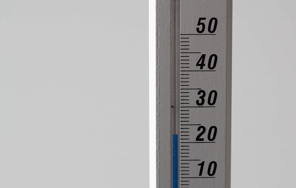 Close Up Photo of Thermometer showing 23 degrees Room Temperature on White Background