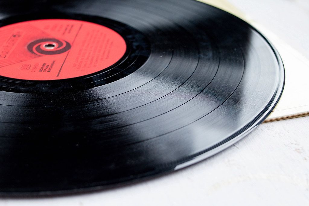 Close Up Photo of Vinyl Record on White Wooden Table