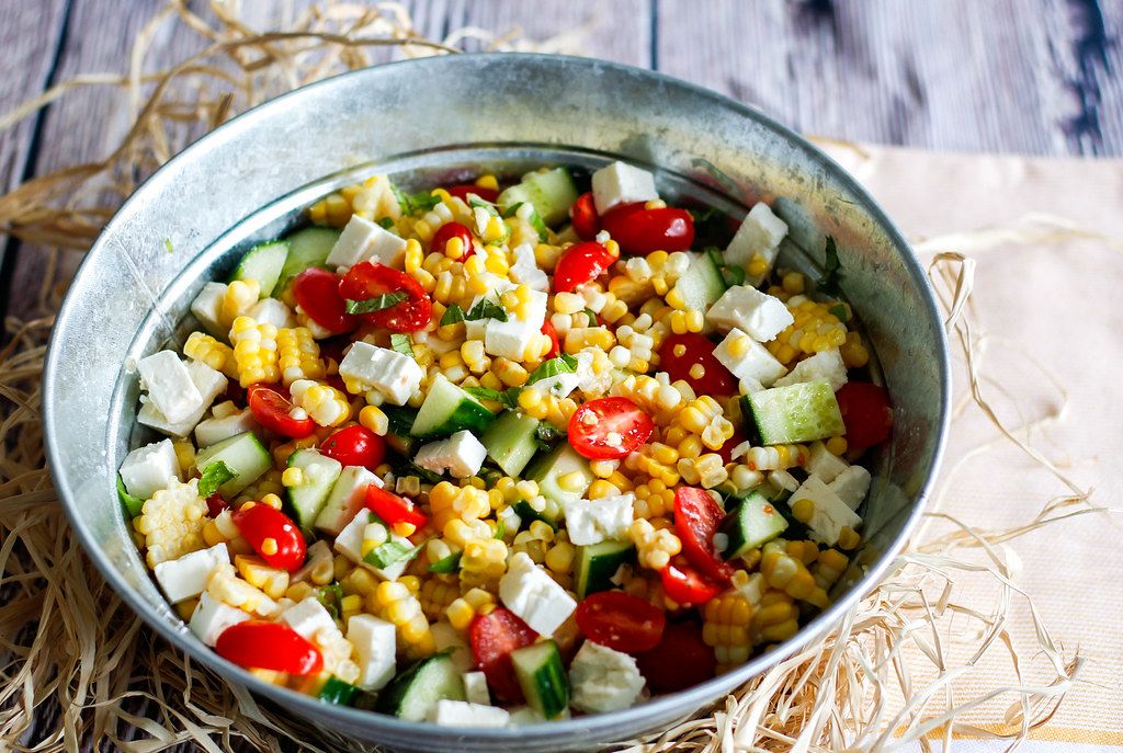 Close Up Top View Food Photo of Corn Salad with Feta Cheese, Cherry Tomatoes, and Cucumber