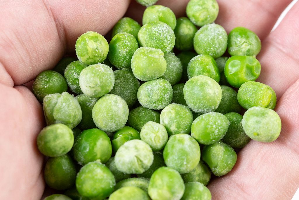 Closeup of Frozen Green Peas in the hand