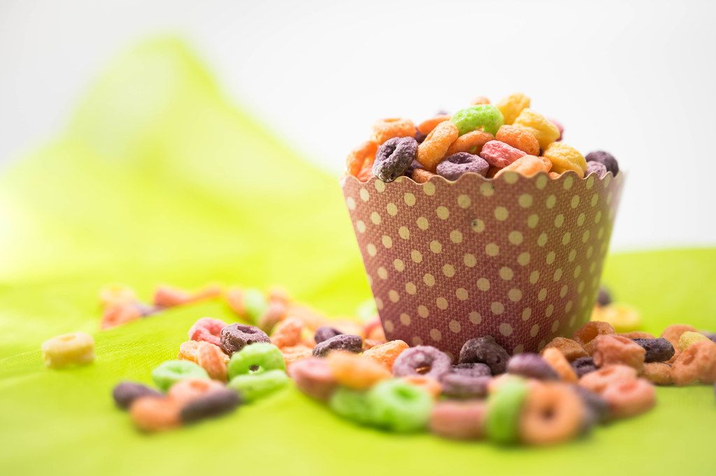 Colorful cereal on a pink cardboard cup