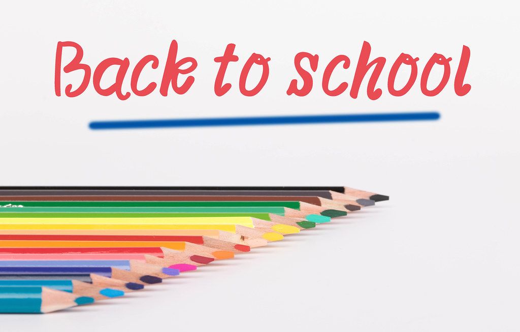 Colorful pencils on white background with text Back to school