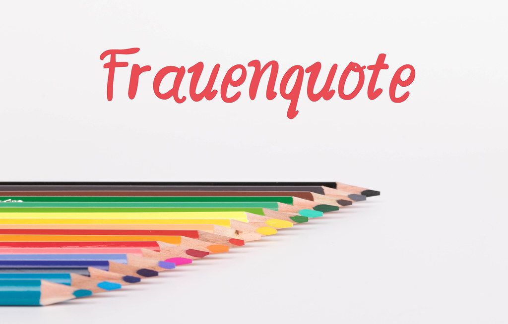 Colorful pencils on white background with text Frauenquote
