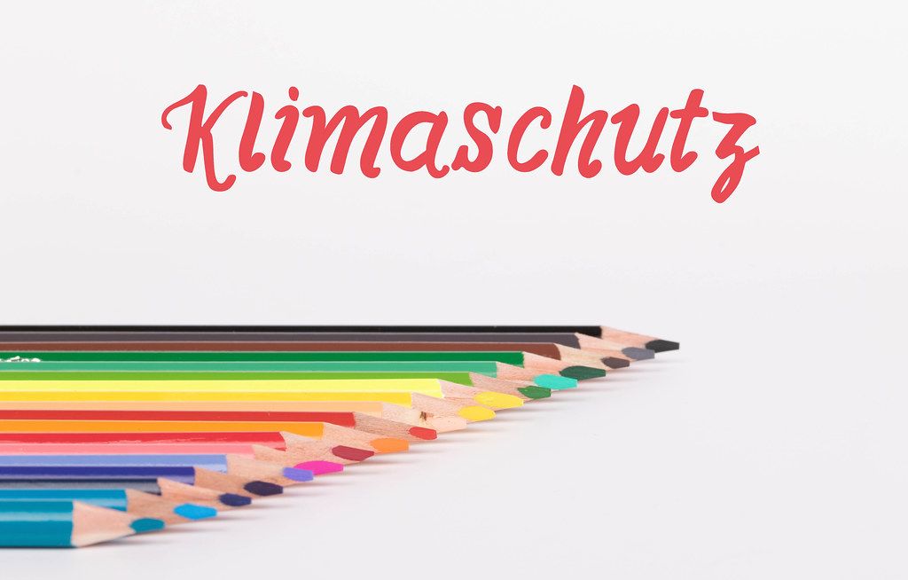 Colorful pencils on white background with text Klimaschutz