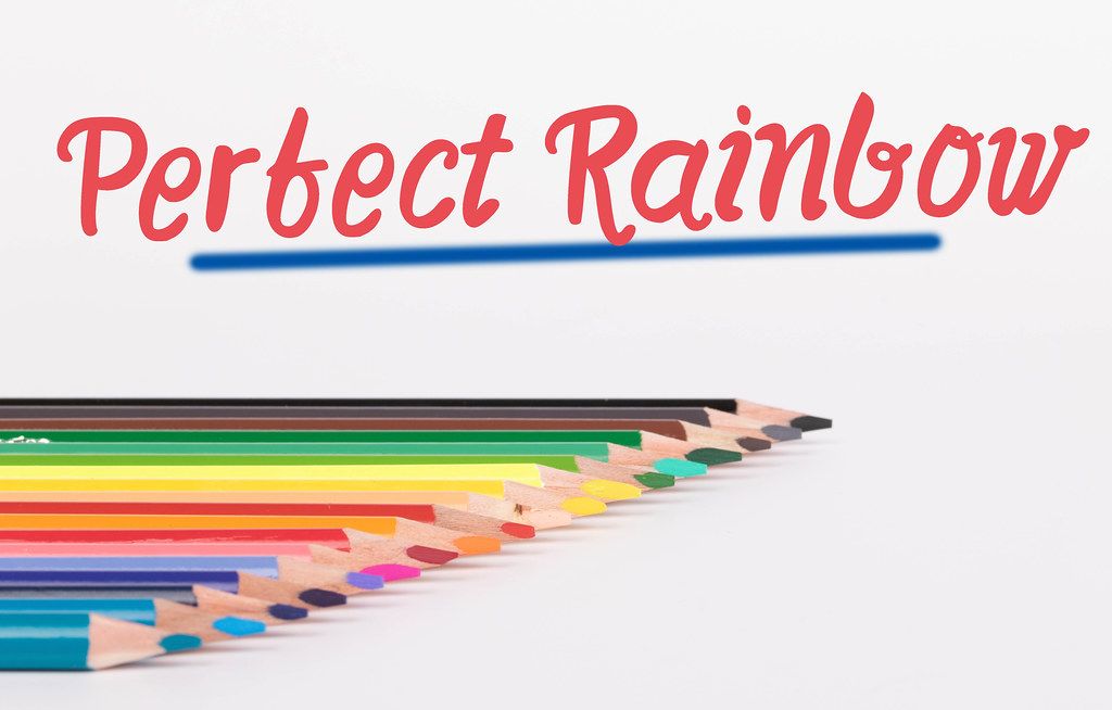 Colorful pencils on white background with text Perfect Rainbow