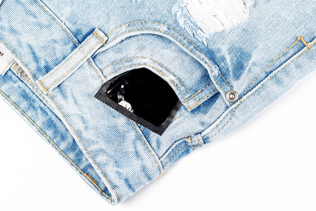 Condom in the pocket of women's shorts. The concept of protection