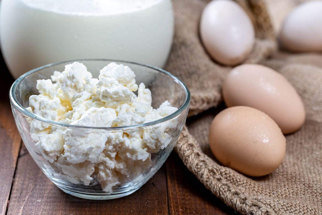 Cottage cheese, milk and eggs on a wooden table