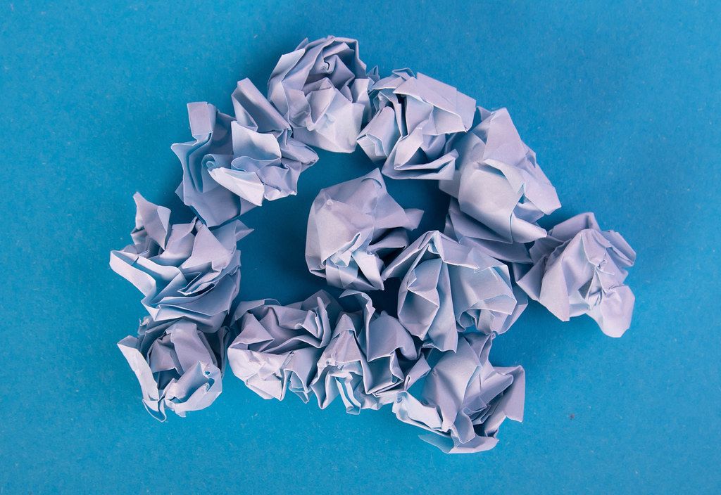 Crumpled Pieces of Paper on a blue Background