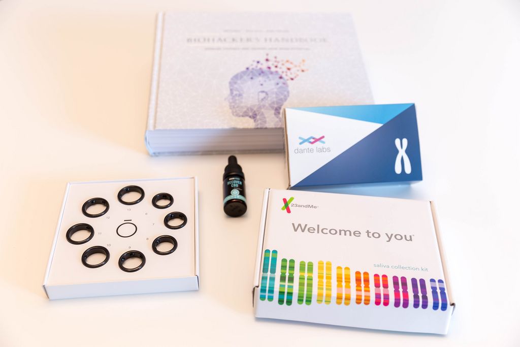 Dante Labs Full DNA Analysis Kit, 23andMe Saliva Collection Kit, Oura Ring Size Kit and Recover CBD with the Biohacker's Handbook in the background