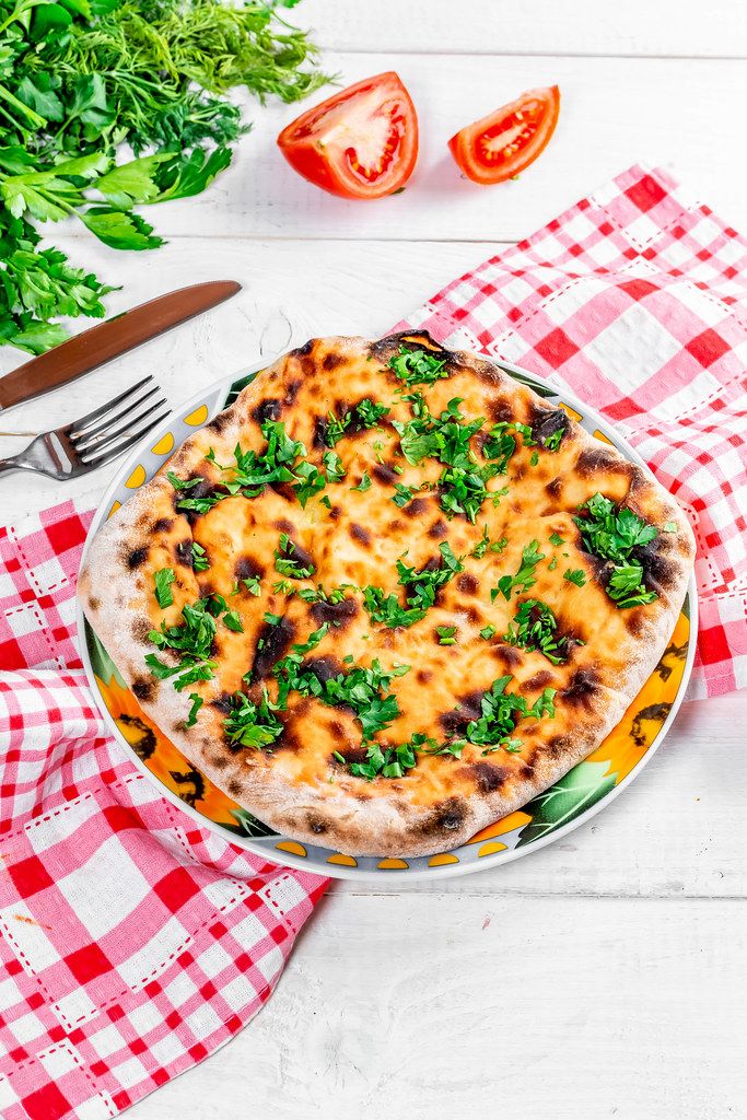 Delicious baked khachapuri with kitchen appliances, herbs and tomatoes (Flip 2019)