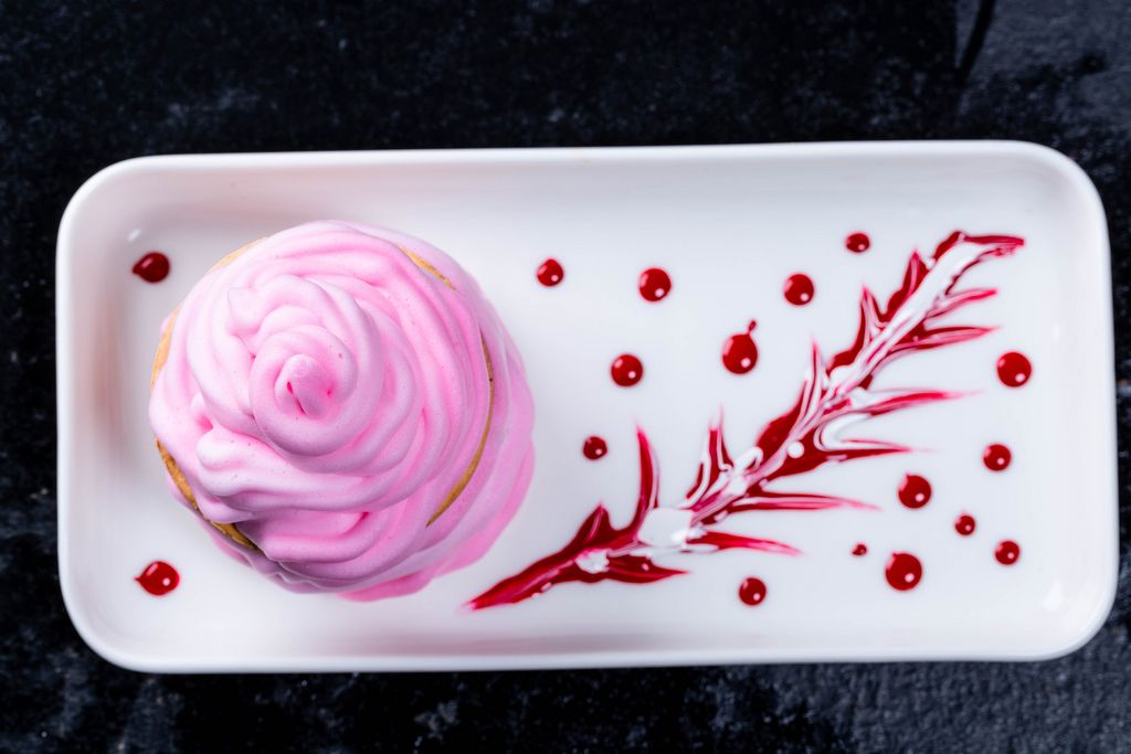 Delicious pink dessert with cream and sweet berry sauce