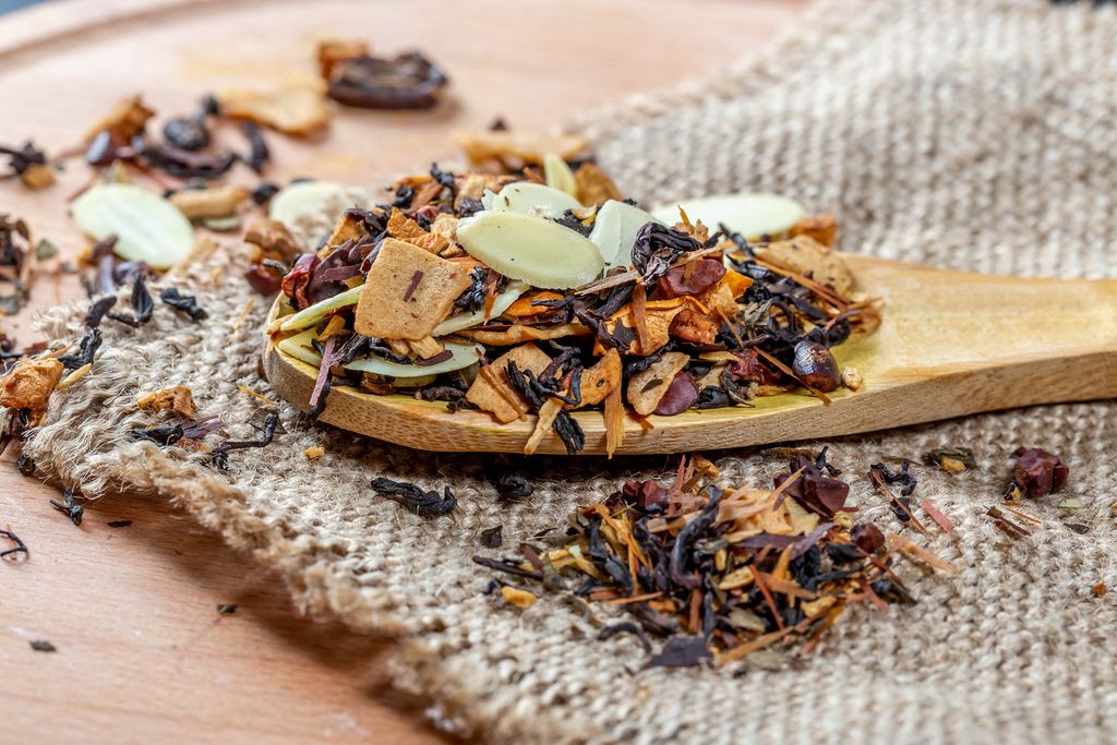 Delicious tea with dried fruits and nuts in a wooden spoon