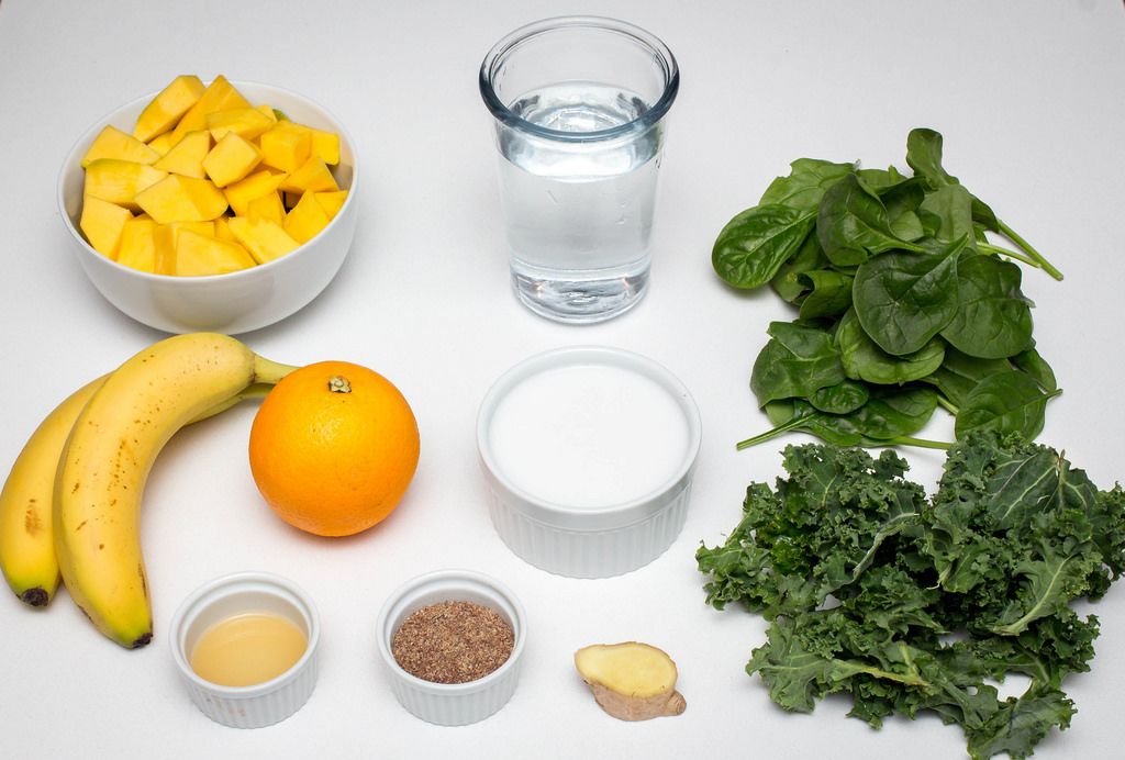 DIe Zutaten für einen gesunden vegan Smoothie - Ananas, Bananen, Orange, Spinat, Grünkohl, Kokosmilch, Leinsamen und Wasser