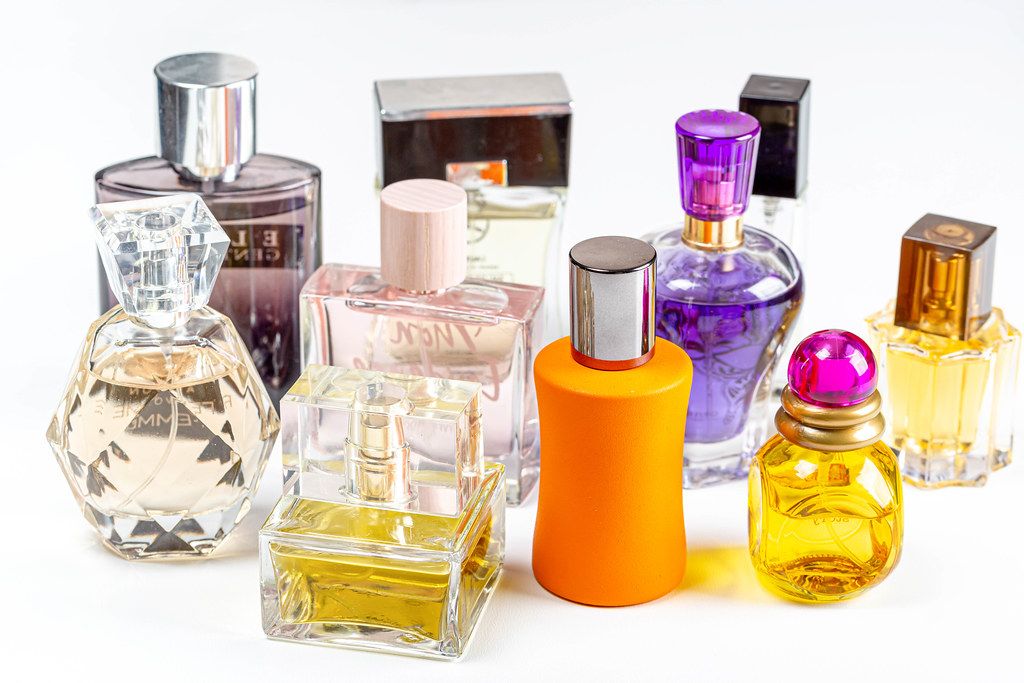 Different perfume bottles on light background