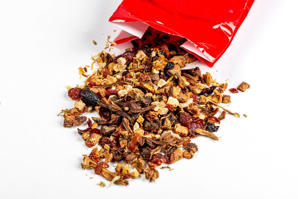 Dried fruit tea spills out of the red packaging