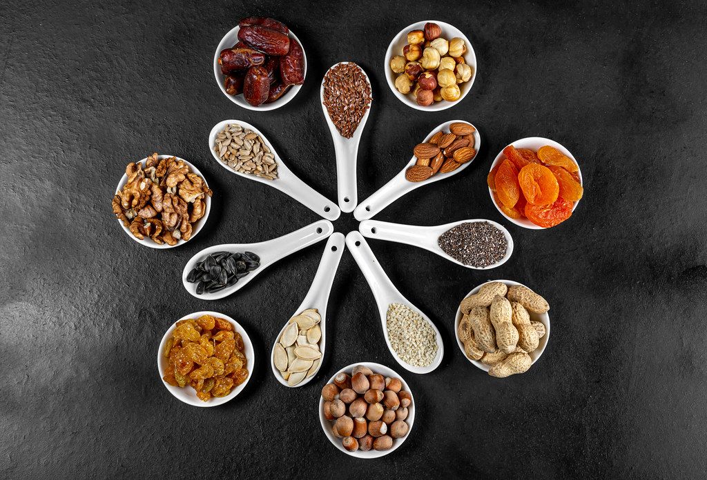 Dried-fruits-nuts-and-seeds-in-spoons-and-bowls-on-a-black-background-top-view.jpg