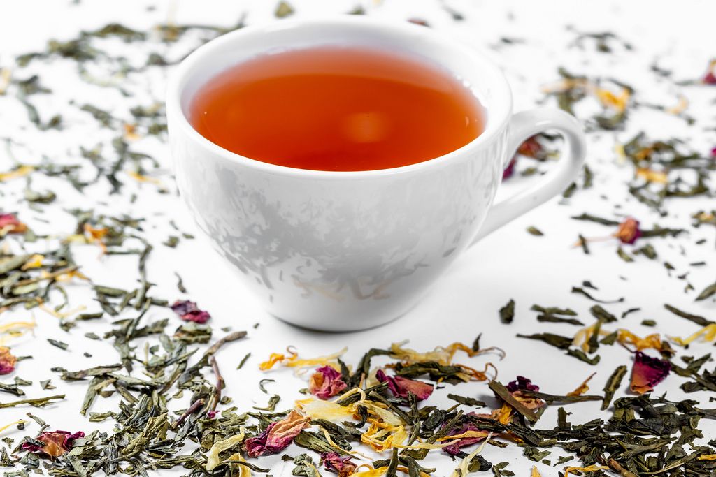 Dried tea with petals and a Cup of fresh tea