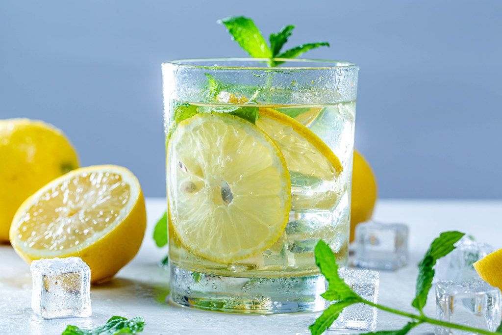 Drink with fresh lemons, mint and ice in glass