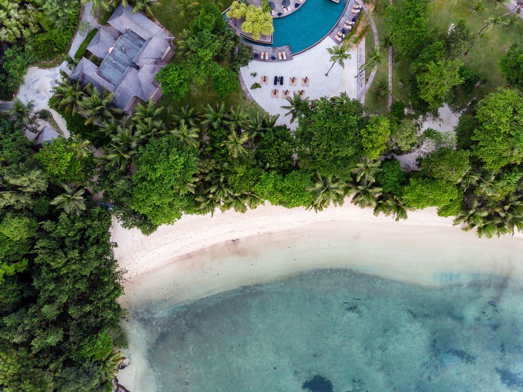 Drohnenbild des Strandabschnitts Port Glaud und Spa-Bereichs des Constance Ephelia Resort auf Mahé, Seychellen