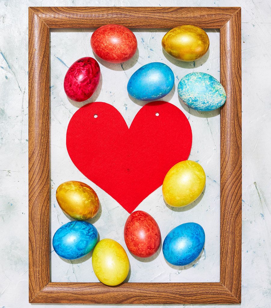 Easter concept. Colorful easter eggs placed in the wooden picture frame (Flip 2020)