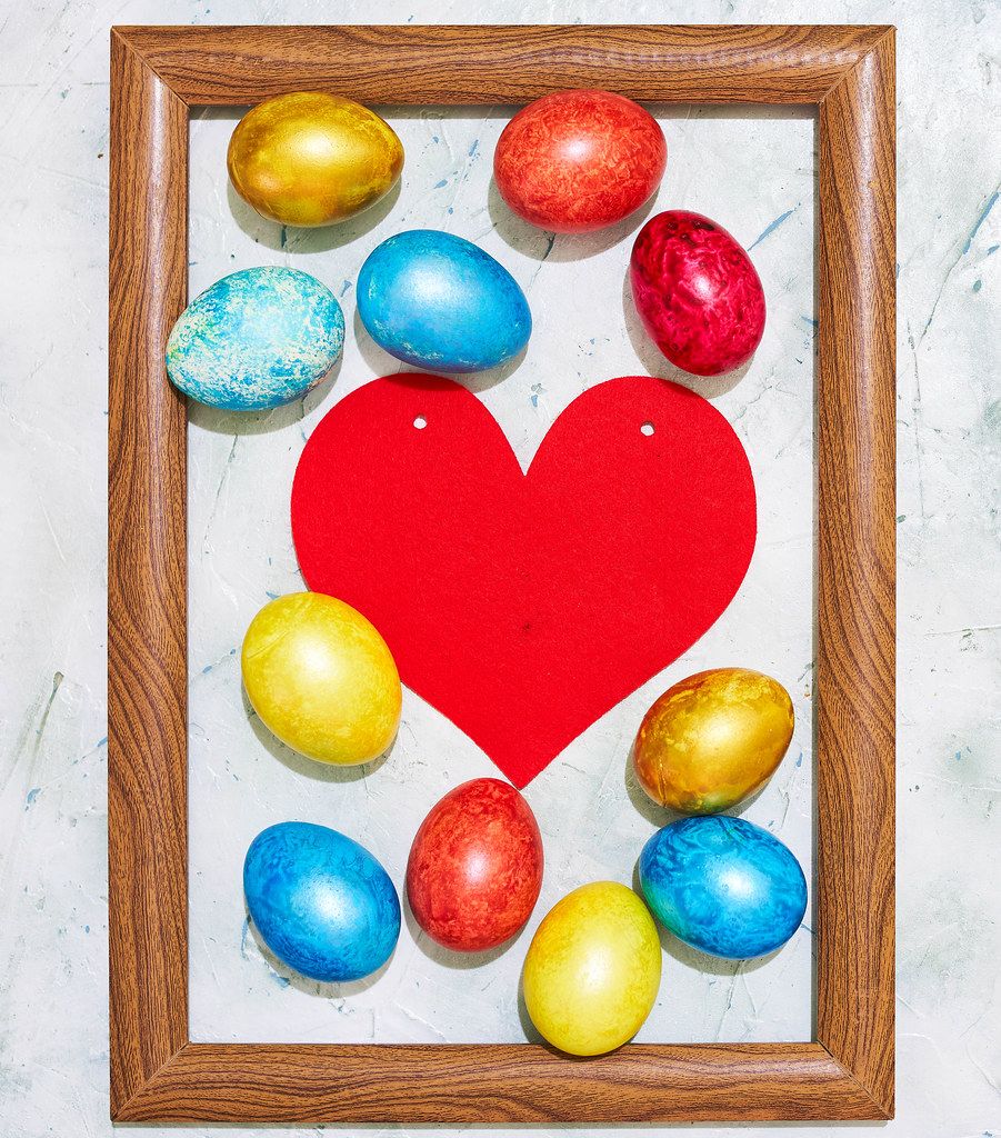 Easter concept. Colorful easter eggs placed in the wooden picture frame.jpg