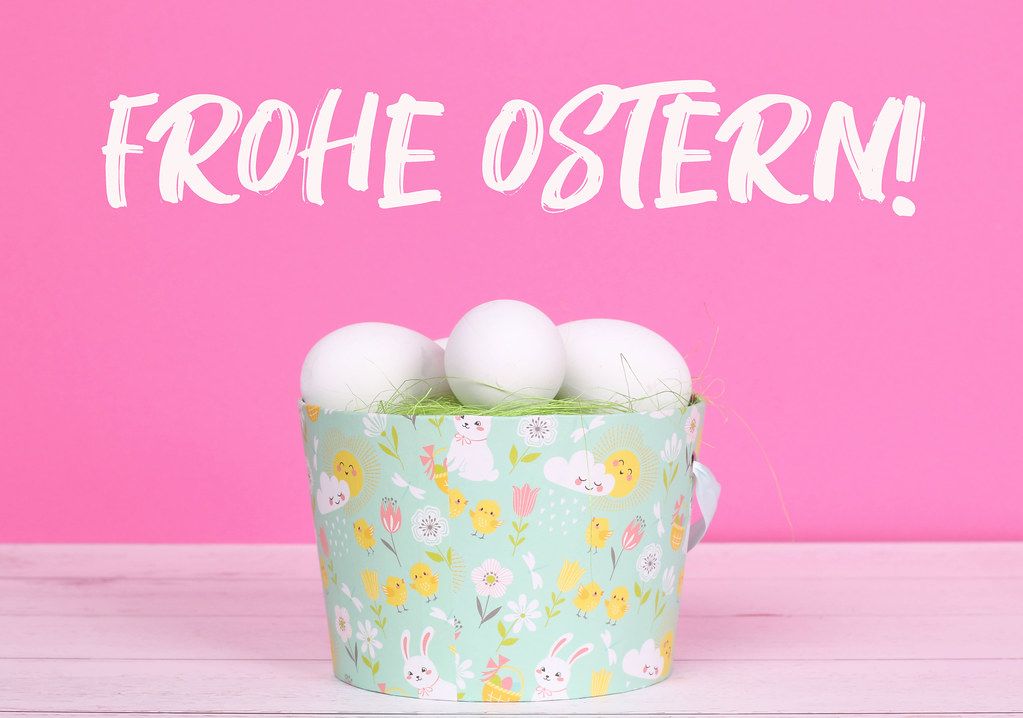 Easter eggs in a basket with pink background and Frohe Ostern text