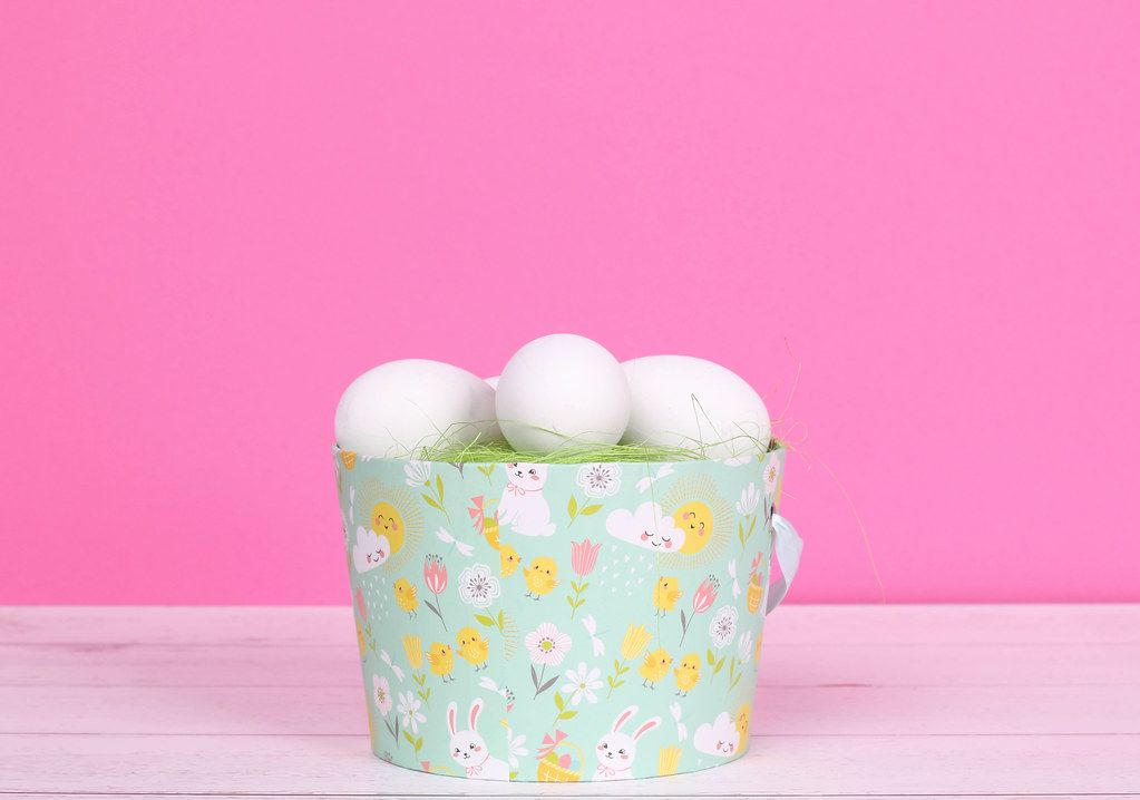 Easter eggs in a basket with pink background